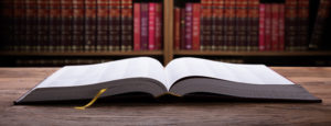 Open Law Book On Wooden Desk With Law Books